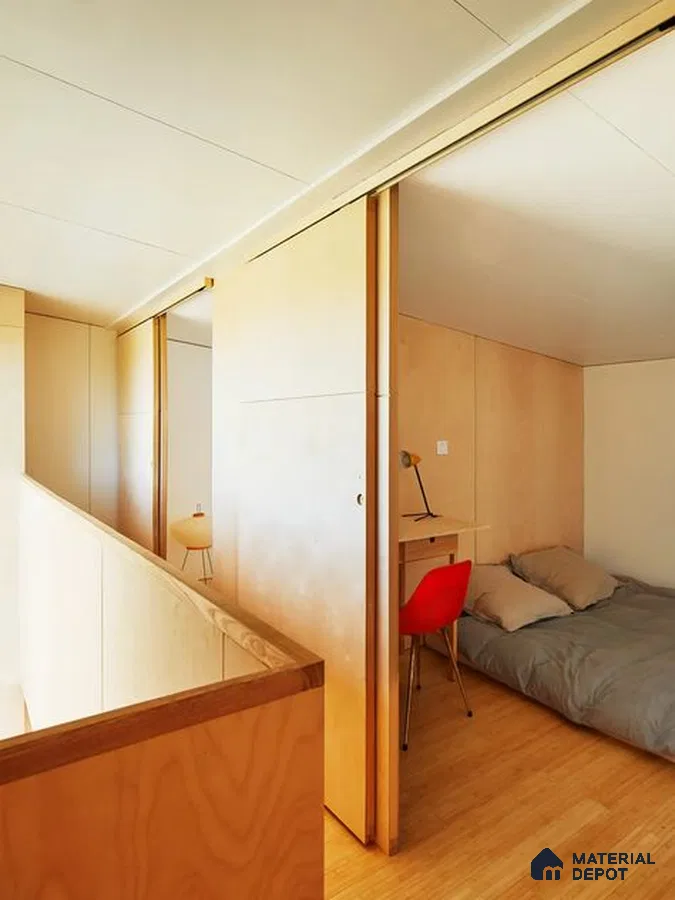 A bathroom with a large tub in the middle of it and wooden flooring next to a white tiled walls and white bathtub in front of a window with lots of a wooden table next to a large window
